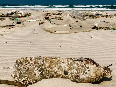 Plastic bottles and other rubbish thrown on the sandy seashore, trash on the sea beach. ecological problem. Environmental pollution. Dirty sandy beach.の写真素材