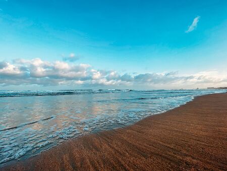 Seascape, sea view. Waves at sea, sea tide, sandy shore. Sea foam. Beautiful clouds in the blue sky. Traveling in Asia.の写真素材