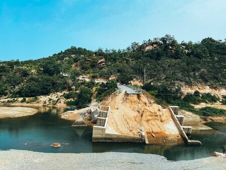The destroyed bridge over the mountain river. Concrete bridge collapsed after the flood. Fallen bridge piers. A river in the mountains. Element. End of the roadの写真素材