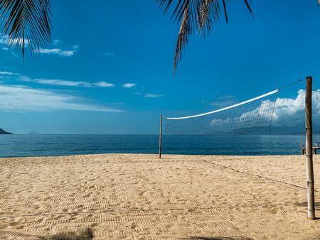 Beach volleyball court on the sandy shore near the sea. No one at the site. Sea view, sea waves, sunny day, windy weatherの写真素材