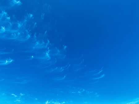 Blue sky with white clouds background. Clear sunny day, with scattered, beautiful clouds in a clear blue skyの写真素材