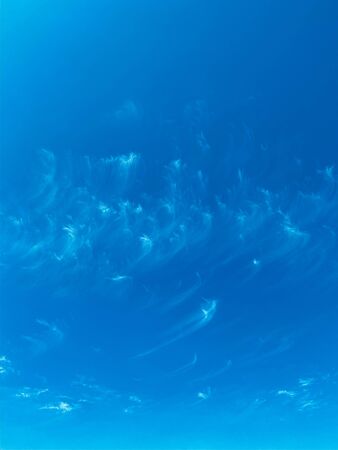 Blue sky with white clouds background. Clear sunny day, with scattered, beautiful clouds in a clear blue skyの写真素材