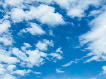 Blue sky with white clouds background. Clear sunny day, with scattered, beautiful clouds in a clear blue skyの写真素材