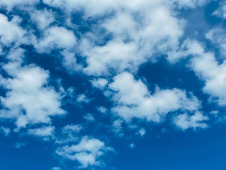 Blue sky with white clouds background. Clear sunny day, with scattered, beautiful clouds in a clear blue skyの写真素材
