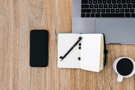 Flat lay of the workplace. Freelance work laptop smartphone and note pad. Morning coffee with...