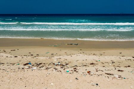 Plastic bottles and other rubbish thrown on the sandy seashore, trash on the sea beach. ecological problem. Environmental pollution. Dirty sandy beach.の写真素材