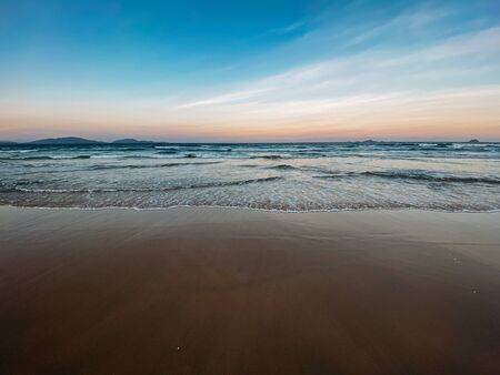 Seascape, sea view. Waves at sea, sea tide, sandy shore. Sea foam. Beautiful clouds in the blue sky. Traveling in Asia. Sunset at sea, colorful sky. Copy placeの写真素材