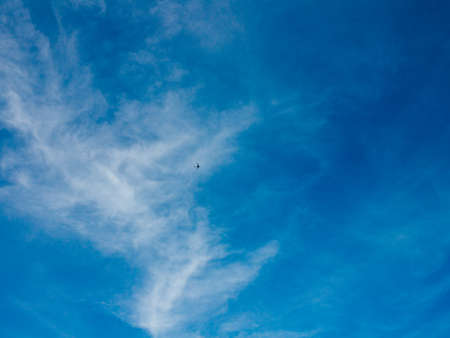 Airplane against the background of a blue sky with light rare clouds, natural background. Flight....