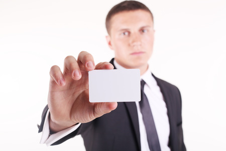 Businessman showing his business card. Shallow depth of field - focus on fingers and card. You can just add your text there.の写真素材