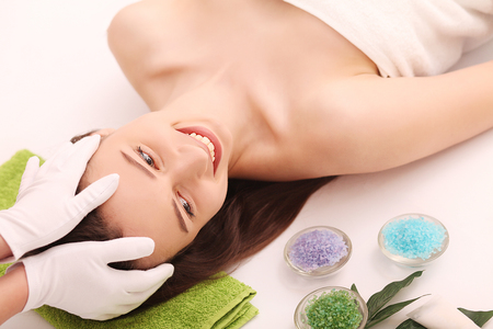 Spa. Care Facial. Beautiful Young Woman Getting a Face Treatment at Beauty Salon.の写真素材