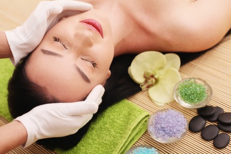 Spa. Care Facial. Beauty young woman gets a head massage in the salon.の写真素材