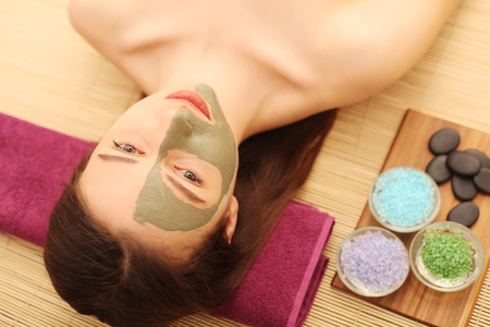 Spa. Care Facial. Beautiful young woman relaxing in the spa salon.の写真素材