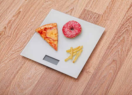 Diet. The concept of junk food on weight. Healthy Lifestyle. Wooden background.の写真素材