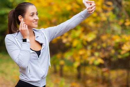 Runner listening music. Fitness, sport and healthy lifestyle concept - smiling runner with earphonesの写真素材