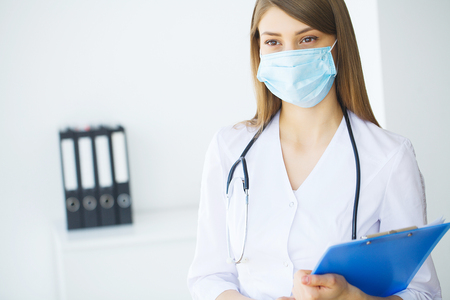 Portrait of young doctor standing in medical officeの写真素材