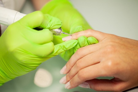 SPA manicure. Woman in a nail salon receiving a manicure by a beauticianの写真素材
