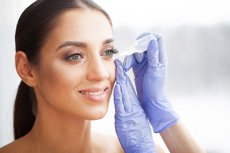 Health and Beauty. Eye Care. Beautiful Young Woman Holding Drops For Eyes. Good Vision. Happy Girl with Fresh Lookの写真素材