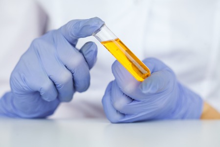 Biological test. Woman holding flask in lab. The scientist,dermatologist testing the organic natural...