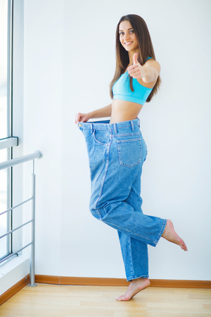 Diet. Beautiful Sporty Woman Showing How Much Weight She Lostの写真素材