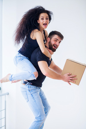 Moving day. Happy young couple carrying boxesの写真素材