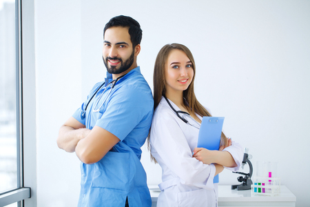 Improving modern medicine. Young scientists making experiments while sitting in the laboratoryの写真素材