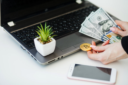Close-up woman buying online with cryptocurrency concept, woman holding golden crypto coinの写真素材