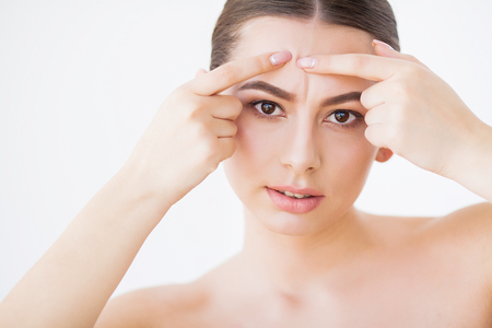 Skin Care. Beautiful Woman Squeezing Pimple at Bathroom Mirrorの写真素材