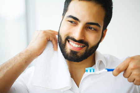 Beautiful Smiling Man Brushing Healthy White Teeth With Brush. High Resolution Imageの写真素材