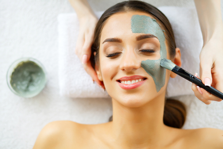 Beautiful Young Woman Getting a Face Treatment at Beauty Salon.Skin and care. Beautiful Woman Lying With Face Mask. Pure and Beautiful Skin.の写真素材