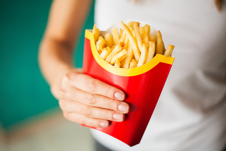 Weight loss and diet. Woman with portion of french friesの写真素材