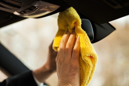Cleaning car. Hand with microfiber cloth cleaning car interior