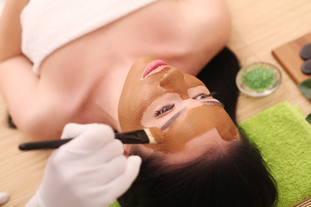 Spa. Care Facial. Beautiful Young Woman Getting a Face Treatment at Beauty Salonの写真素材
