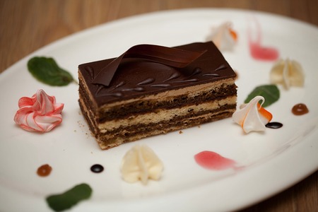 Delicious chocolate cake on plate on wooden background