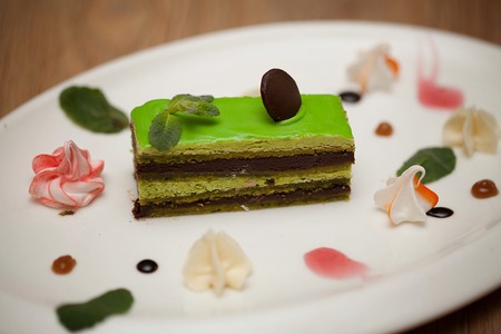 Tasty piece of chocolate cake on wooden table background