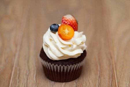 Delicious cupcakes with berries on wooden table close upの写真素材