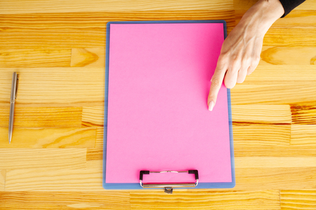 Blank Folder with Pink Paper. Hand that Holding Folder and Handle on White Background. Copyspace. Place for Textの写真素材