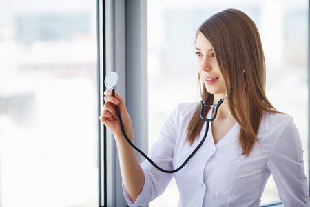 Clinic. Portrait of young doctor standing in medical officeの写真素材