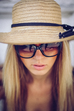 Noise. Vintage Style. Stylish woman in white hat standing on old townの写真素材