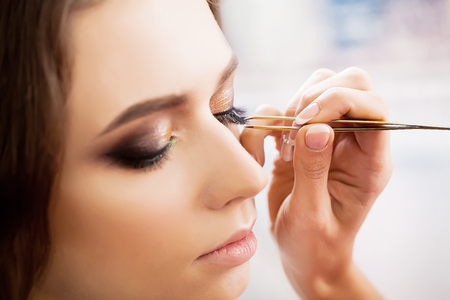 young, beautiful girl put on make-up in a beauty salonの写真素材