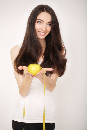 Diet. Girl on a diet measuring waist and abdomen centimeter and looks much fat.の写真素材