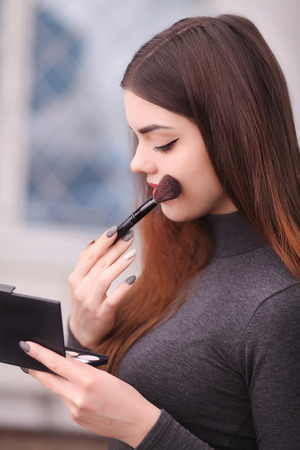 Beauty Girl with Makeup Brush. Natural Make-up for Brunetteの写真素材
