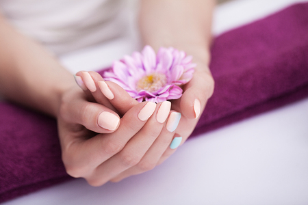 Nails in the spa. Beautiful manicure. Spa treatments for hands and nails. Soaking the hands in the handkerchief. Flowers The concept of spa and beauty.の写真素材