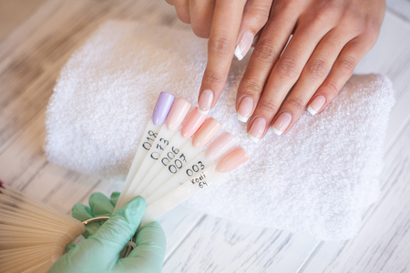Manicure. Skillful master of manicure holding file in her hands while working in her beauty salonの写真素材