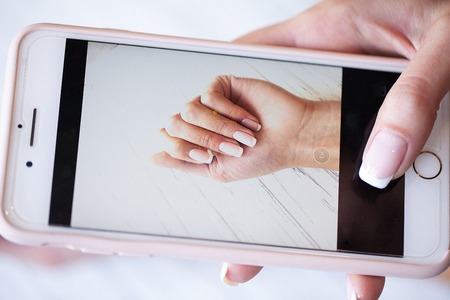 Manicure. A woman takes a photograph of the manicure nails handの写真素材