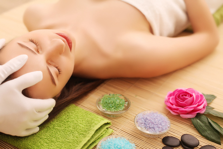 Close-up of a young woman getting spa treatment at beauty salon. spa face massage. facial beauty treatment. spa salon.の写真素材