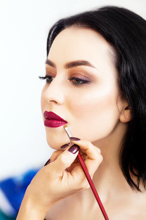 make up artist applying eye shadow to a womanの写真素材