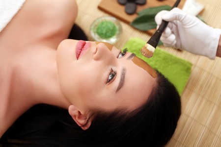 Spa therapy for young woman having facial mask at beauty salon - indoorsの写真素材
