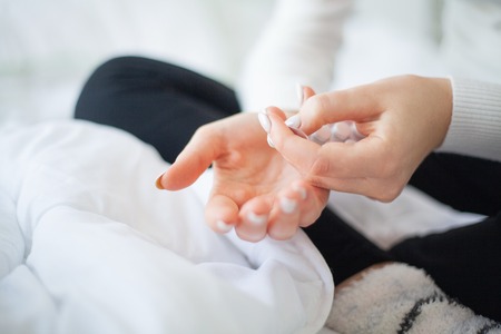 High temperature. Close up sick woman hold in her hand pillの写真素材
