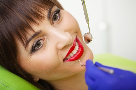Young female patient visiting dentist office. Woman having teeth examined at dentistsの写真素材