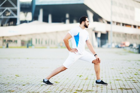 Fitness. Sportsman doing stretching exercises in park